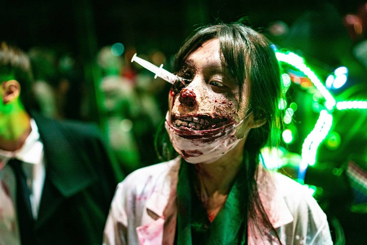 Behind-the-scenes application of SFX makeup for zombies showing hair integration and wound detailing